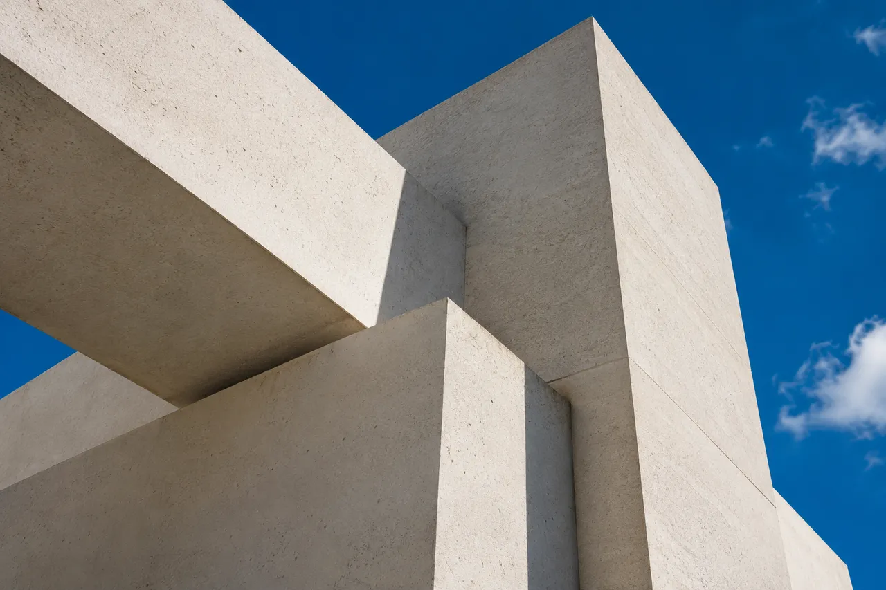 Sculptural pale concrete architecture against a cobalt blue sky